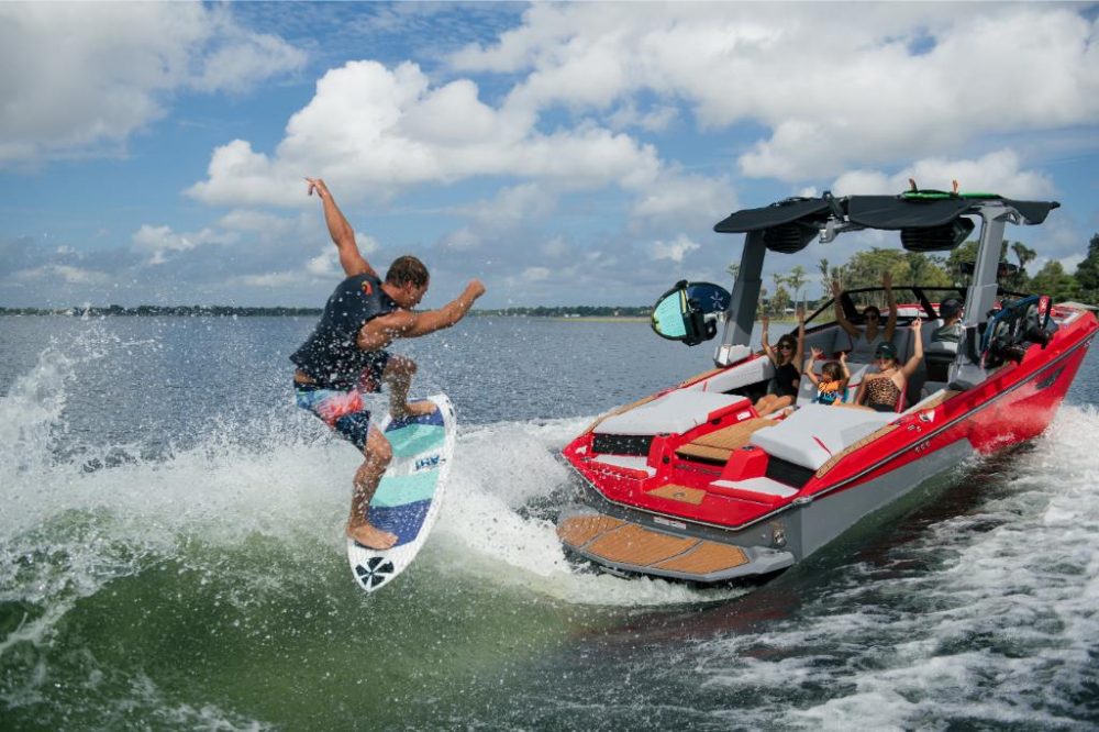 Red Malibu Surf Boat With Man Wake Surfing